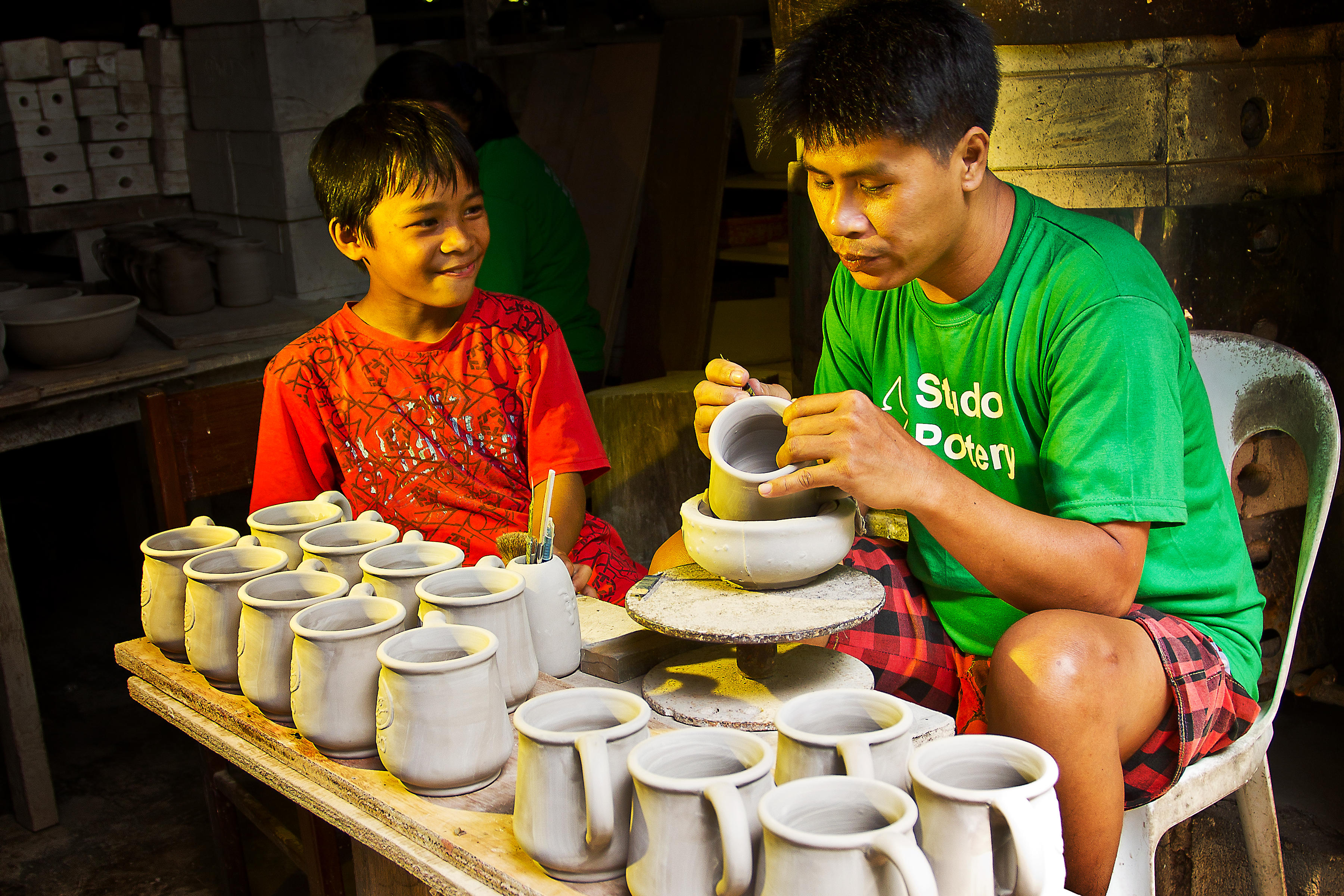 A father in the Philippines teaches his son the basics of pottery. © 2012 Kai, Courtesy of Photoshare