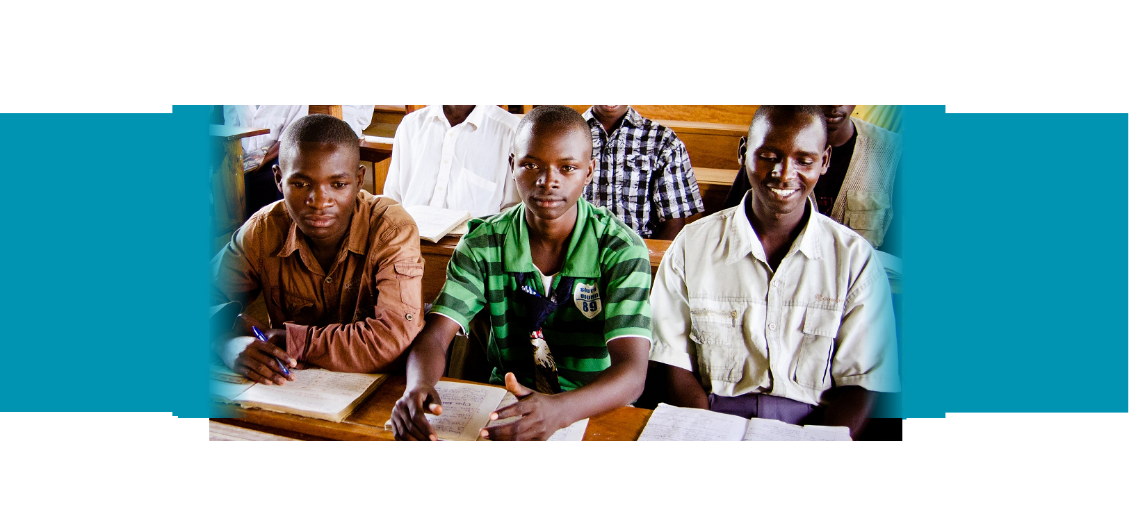 Three boys sitting at a desk. YouthPower Action Mozambique