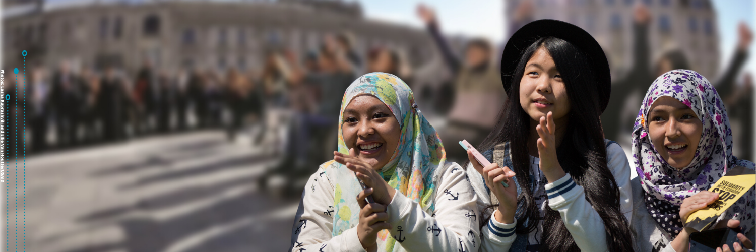 Three young women with head scarf clapping (Photos: Lasha Kuprashvili and Ellie Van Houtte/USAID)