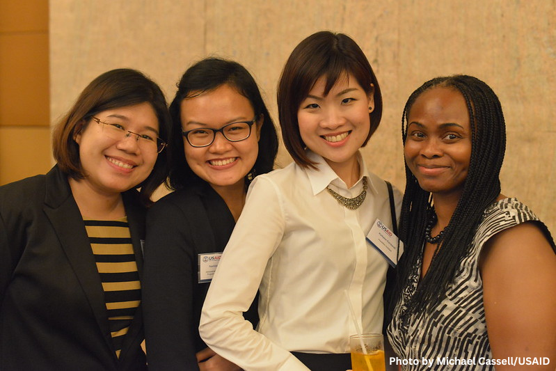 Four young women smiling at a professional reception